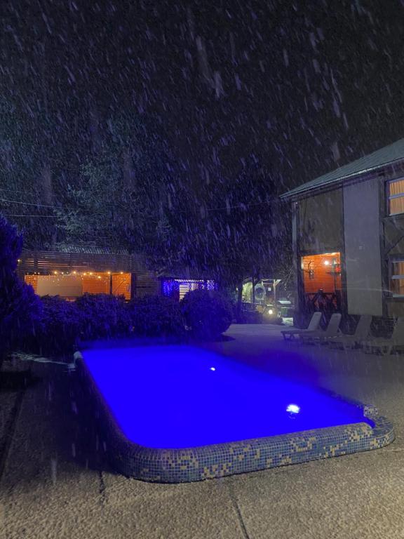 a blue swimming pool in a yard in the snow at Guest house Shulc in Mizhhirya