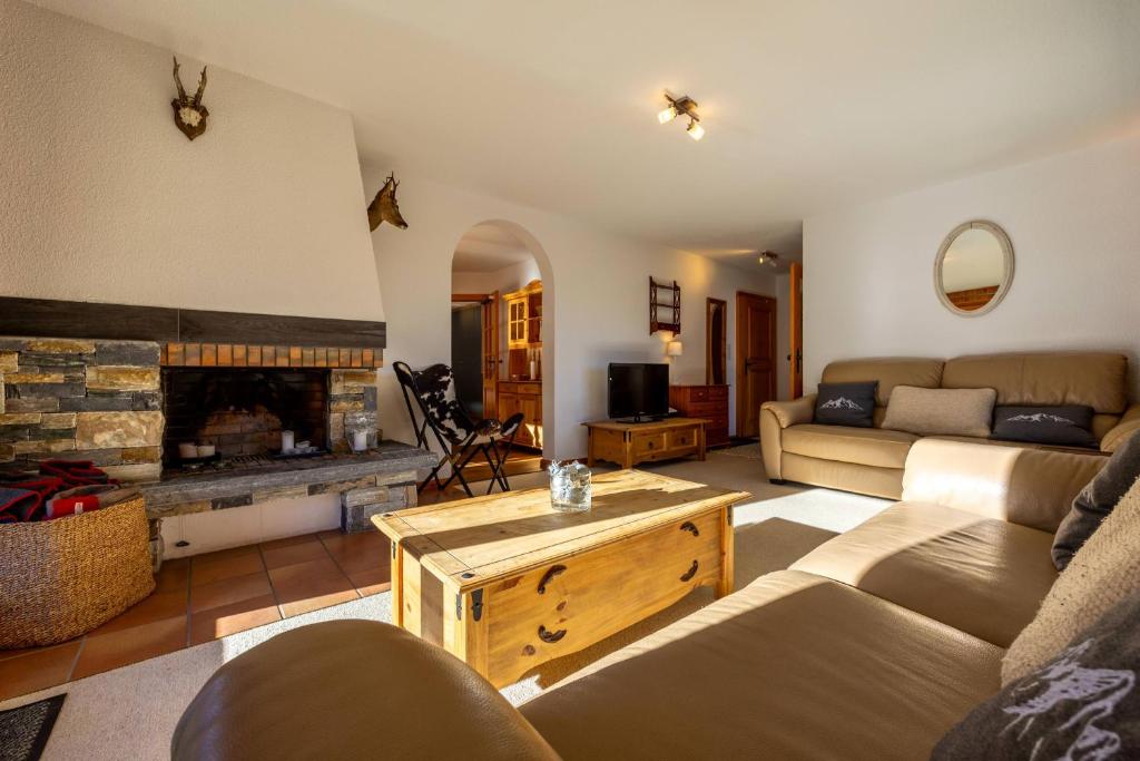 a living room with a couch and a fireplace at Les Busards 18 in Nendaz