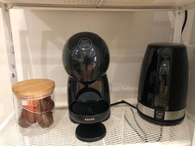 a black coffee maker and a toaster on a shelf at Appart&#39; Bois et Forêt Centre in Saint-Étienne