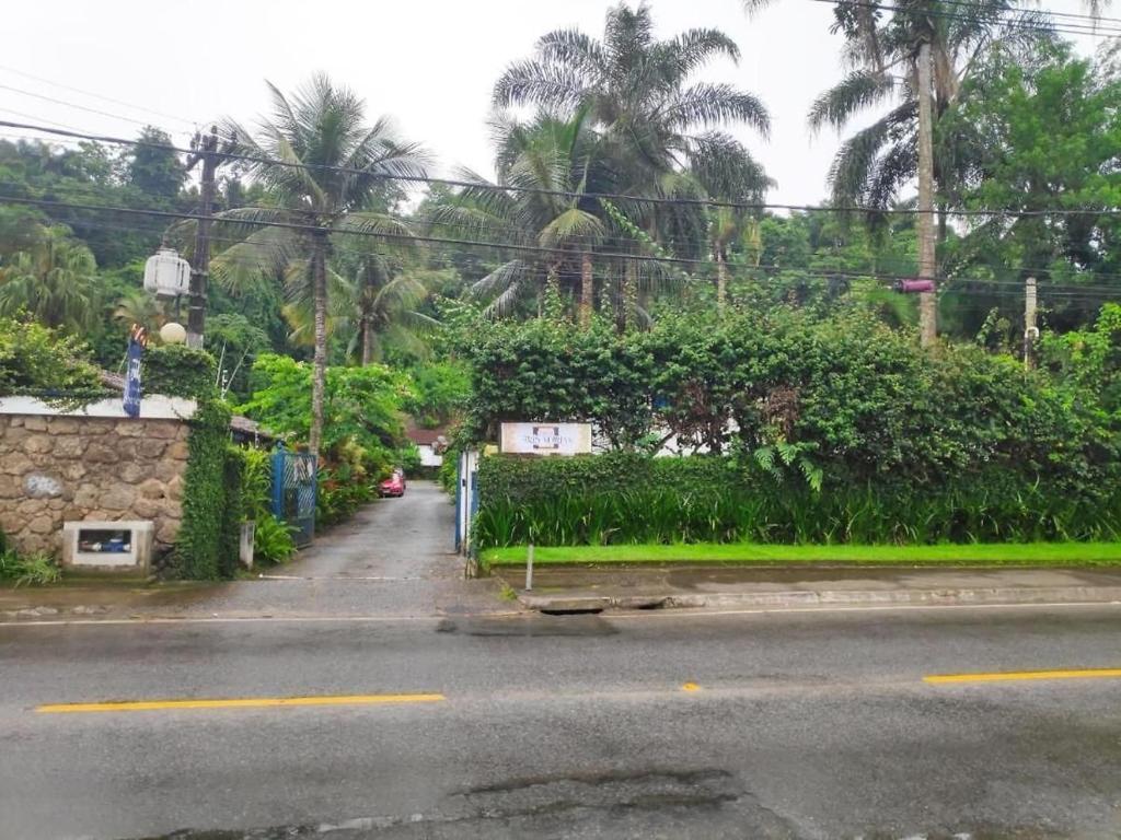 una calle vacía con arbustos verdes y árboles en Villas & Residencial Três Marias à 300 mts do Centro Histórico Paraty en Parati