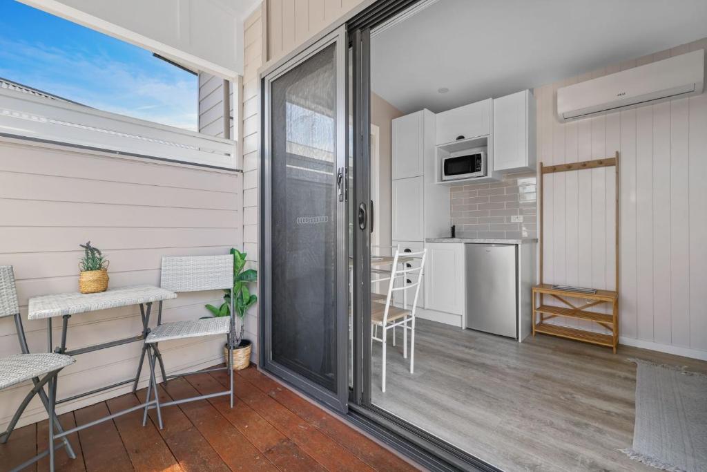 a room with a balcony with a table and chairs at Tiny House Stays House 1 in Sanctuary Point