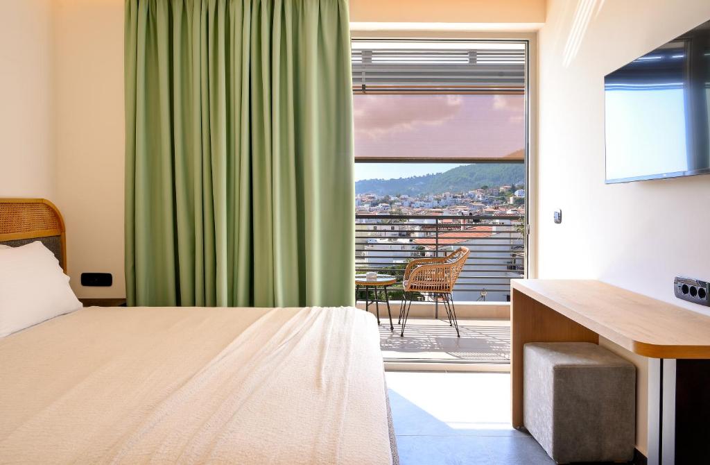 a hotel room with a bed and a large window at Skia, Premium Key Collection in Skiathos Town
