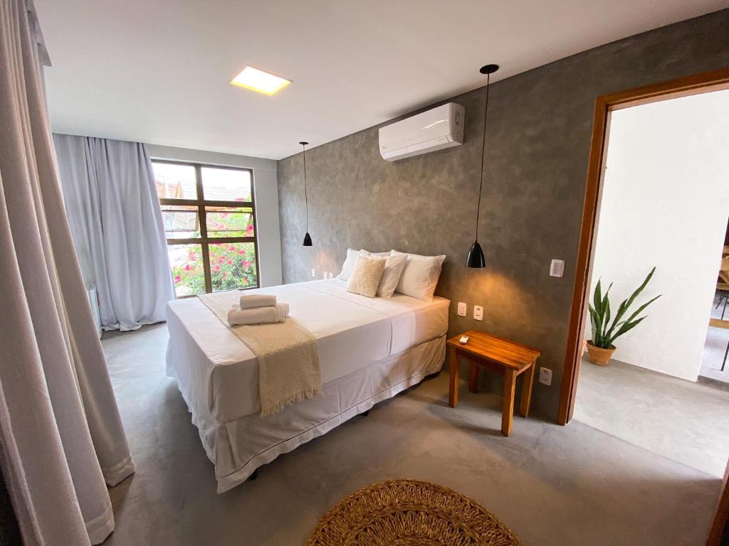 um quarto com uma cama grande e uma janela em Pousada Baobá em Jericoacoara