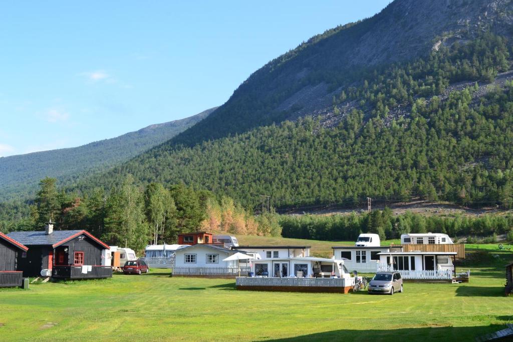 un gruppo di case di fronte a una montagna di Mogard a Skjåk