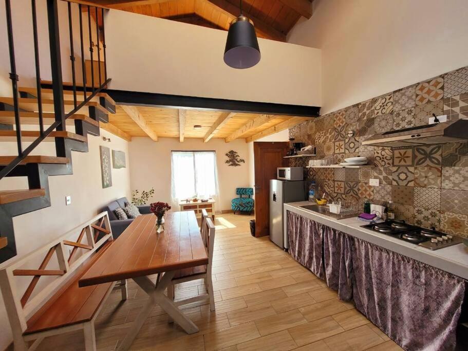 eine Küche und ein Wohnzimmer mit einem Holztisch im Zimmer in der Unterkunft Depto. Arica in San Cristóbal de las Casas
