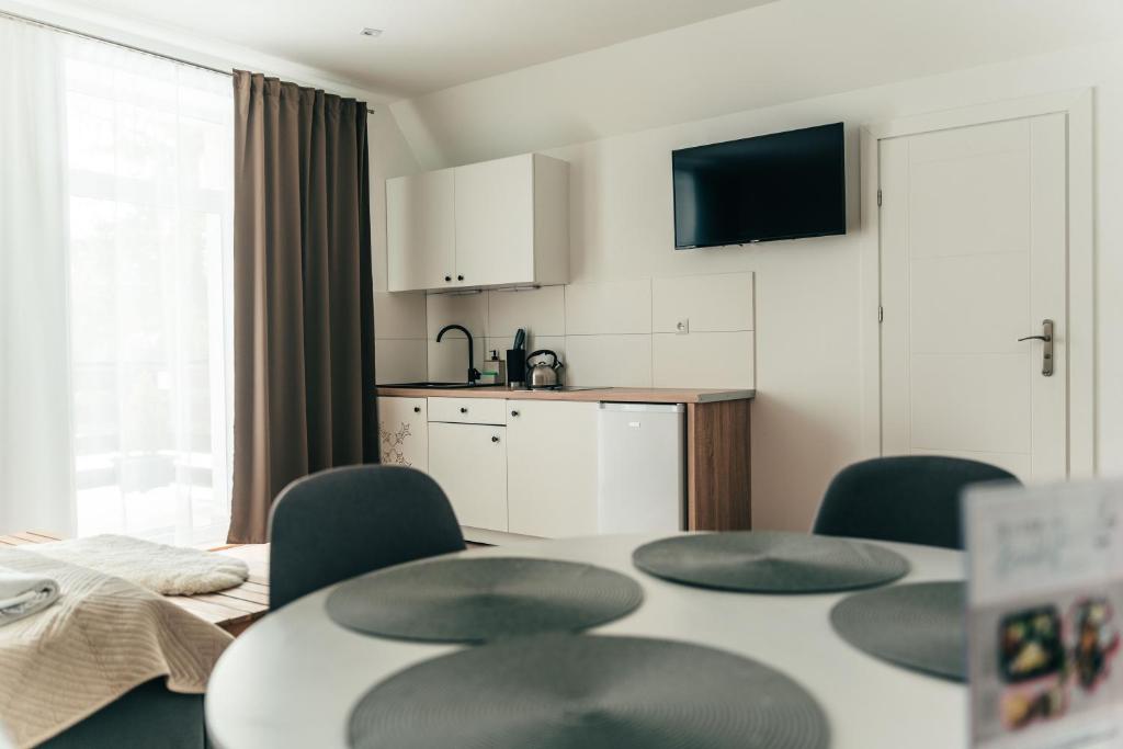 Zimmer mit einem Tisch und Stühlen sowie einer Küche in der Unterkunft Kamieniec No5 Apartments in Zakopane