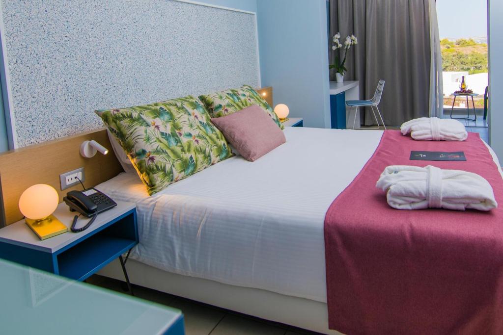 A bed or beds in a room at Lindos Breeze Beach Hotel