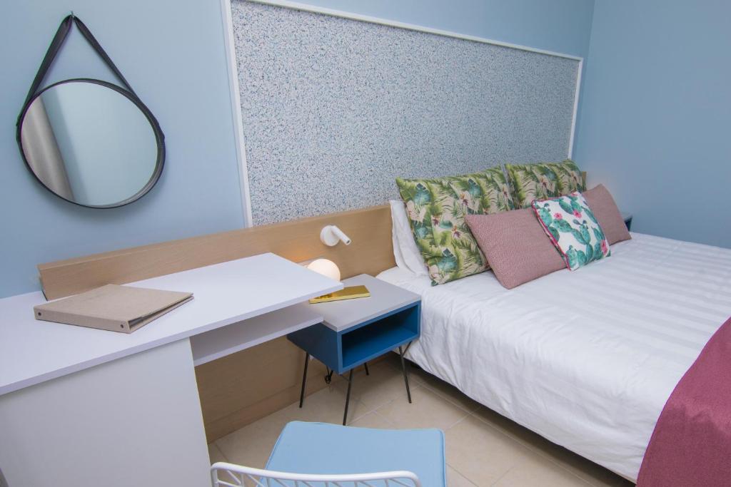 A bed or beds in a room at Lindos Breeze Beach Hotel