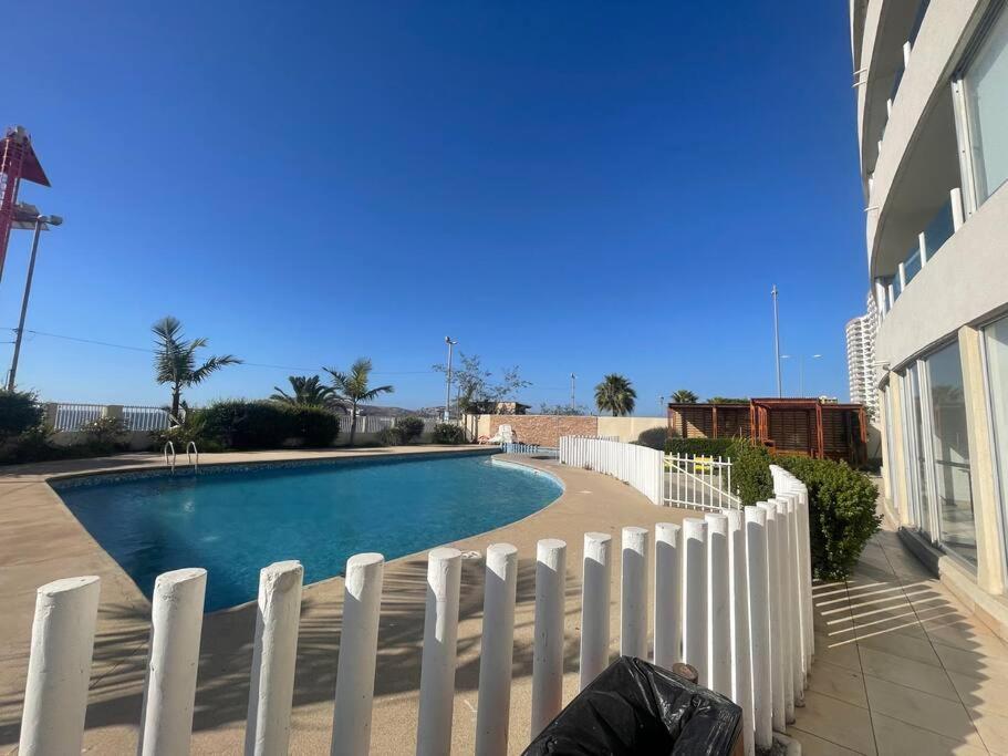 a white fence around a swimming pool next to a house at Departamento En Playa Herradura in Coquimbo