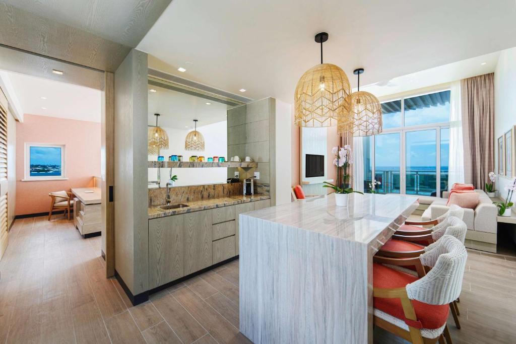 a kitchen with a counter and a living room at Wyndham Grand Barbados Sam Lords Castle All Inclusive Resort in Saint Philip