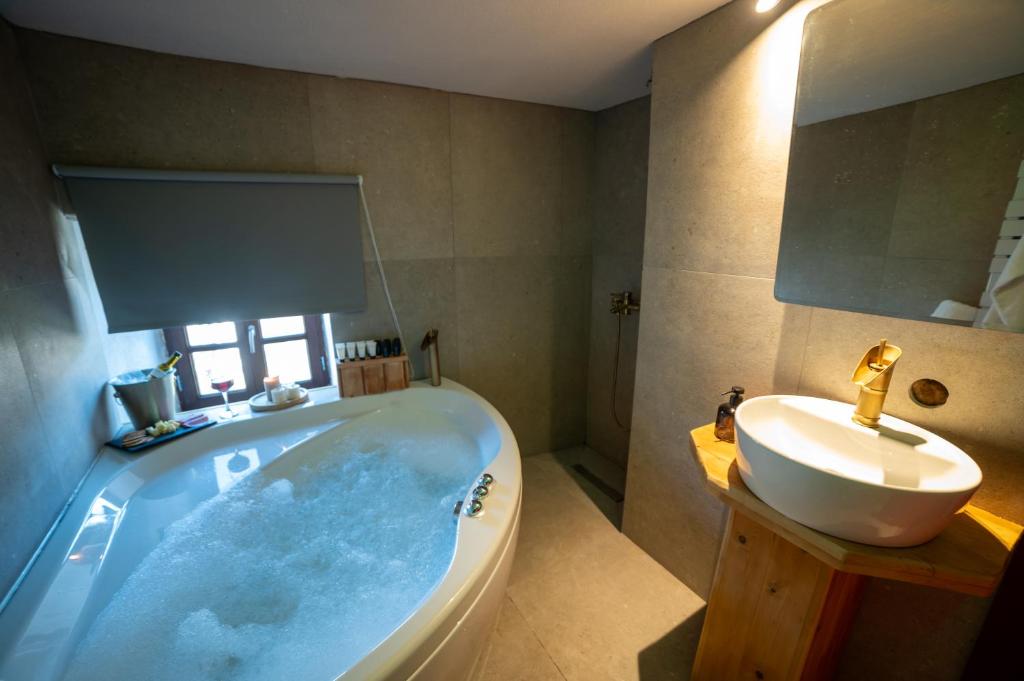 a bathroom with a large tub and a sink at la foret in Metsovo