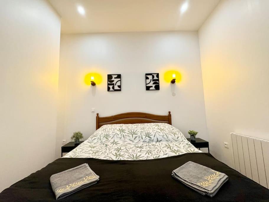 1 dormitorio con 1 cama con 2 toallas en LeCosyWood1*Centre-Ville*TV*WIFI en Calais