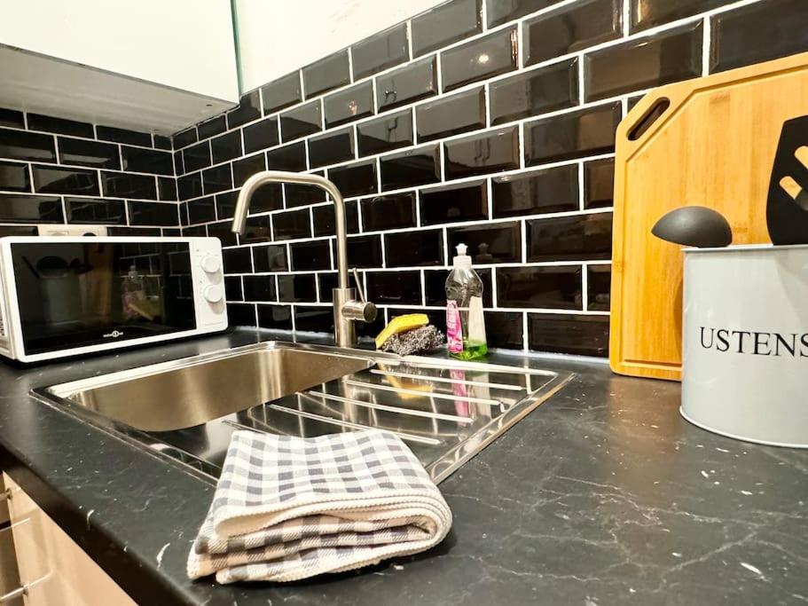 un comptoir de cuisine avec un évier et un micro-ondes dans l'établissement Mohd'or 1 Calais, à Calais