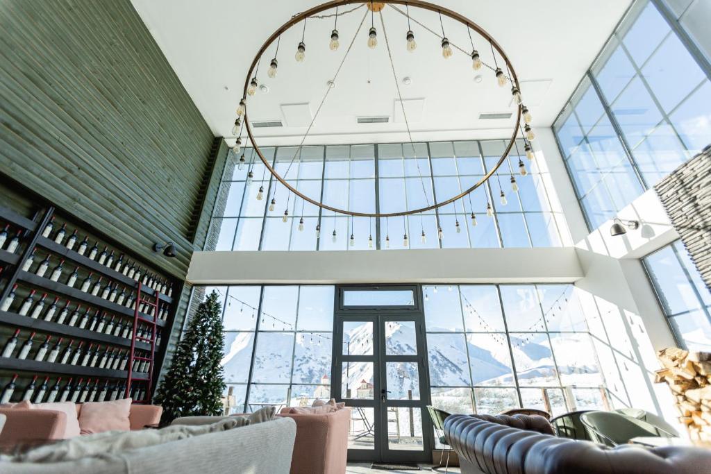 a large room with windows and a large chandelier at Hotel Roshe Gudauri in Gudauri