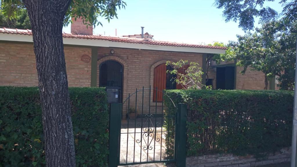 una casa de ladrillo con una puerta y un árbol en Mi Casa en Villa Carlos Paz