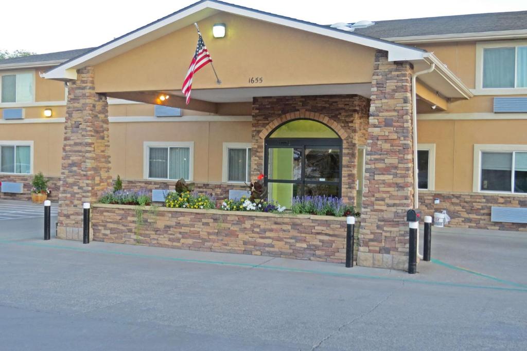 a building with an american flag in front of it at SureStay Plus by Best Western Montrose in Montrose