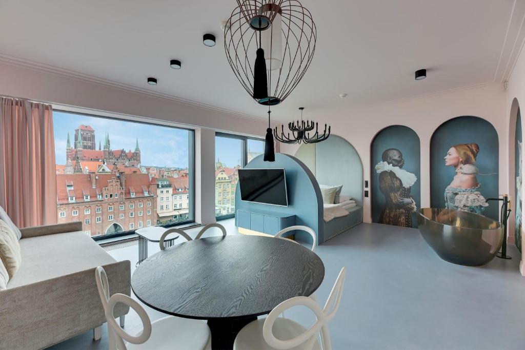 a living room with a table and a large window at Deo Plaza Prestige 1 by Grand Apartments in Gdańsk