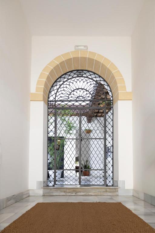 an iron gate in a white room with a rug at Palacio de Luja in El Puerto de Santa María