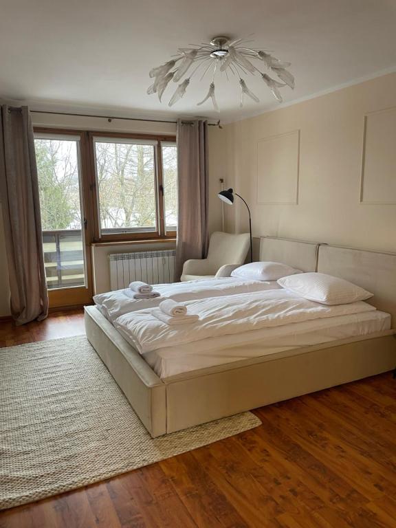 a bedroom with a large bed and a chandelier at Łukaszówki przy Krupówkach in Zakopane