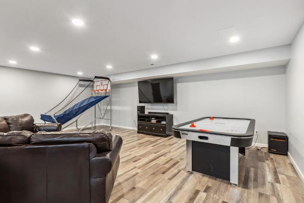 a living room with a couch and a ping pong table at Great Group Getaway: Games Galore + Outdoor Oasis in Painesville