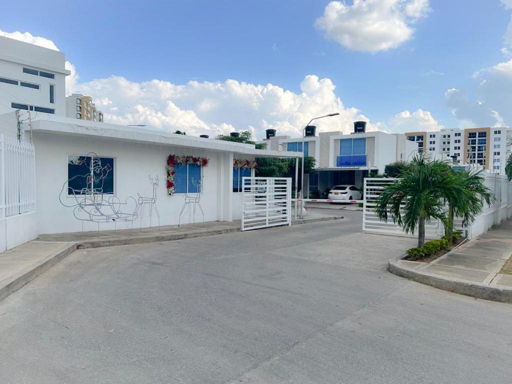 un edificio blanco con una puerta en un estacionamiento en Apartaestudio Amoblado en Valledupar