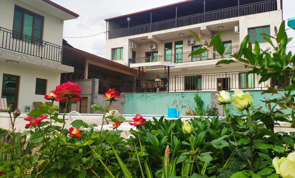a view of a house with flowers in the foreground at APEX Rest house of 10 rooms and pool in Yerevan