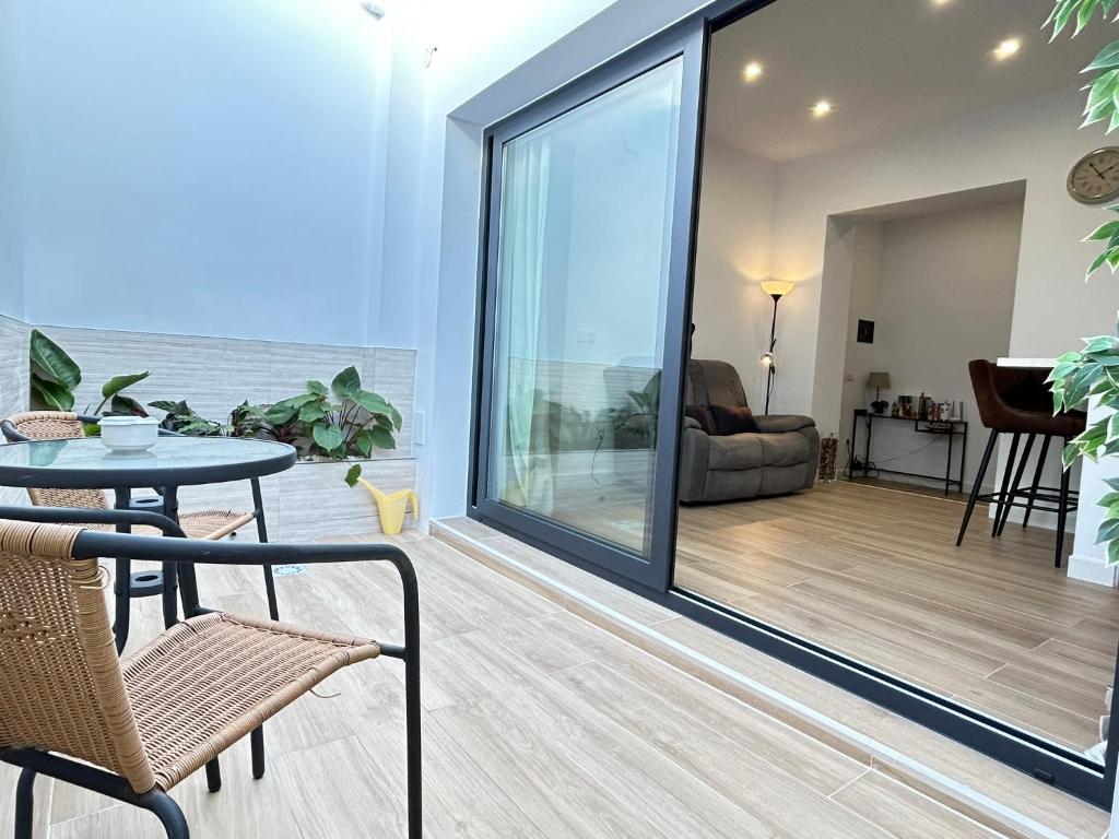 una sala de estar con una gran puerta corredera de cristal en Apartamento El Patio, en Chipiona