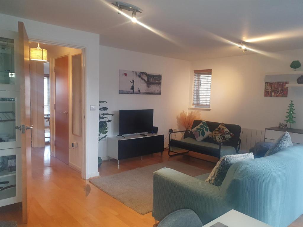 a living room with a couch and a tv at Easy Stay London - Bright and airy 2Bed Apart in London