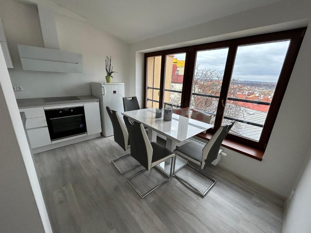 - une cuisine et une salle à manger avec une table et des chaises dans l'établissement Apartment Cimburkova, à Prague