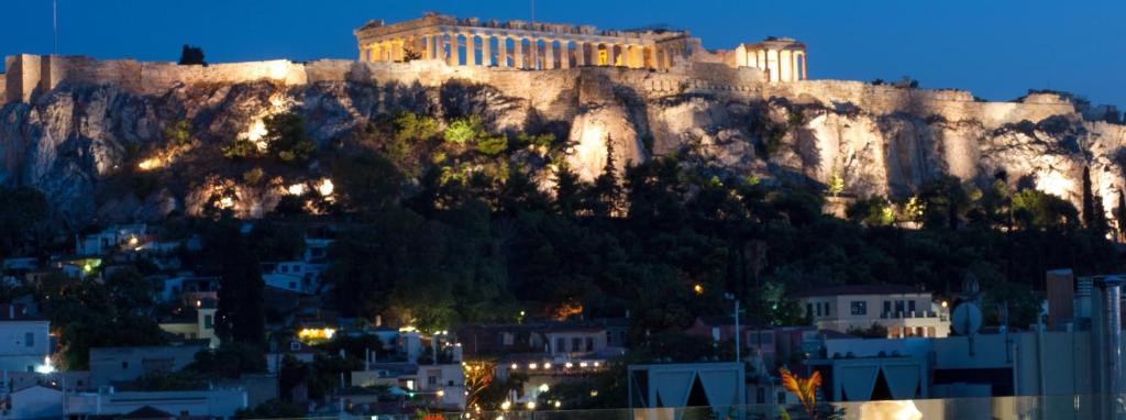 una vista de la acrópolis de Atenas por la noche en Athens Utopia Ermou en Atenas