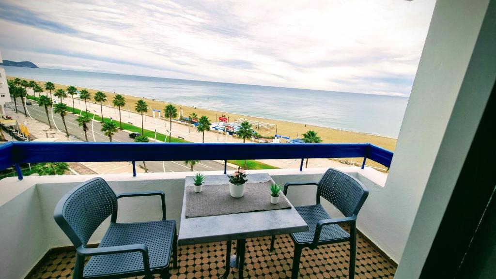 a balcony with a table and chairs and the beach at Apartamento Vista Mar in Martil