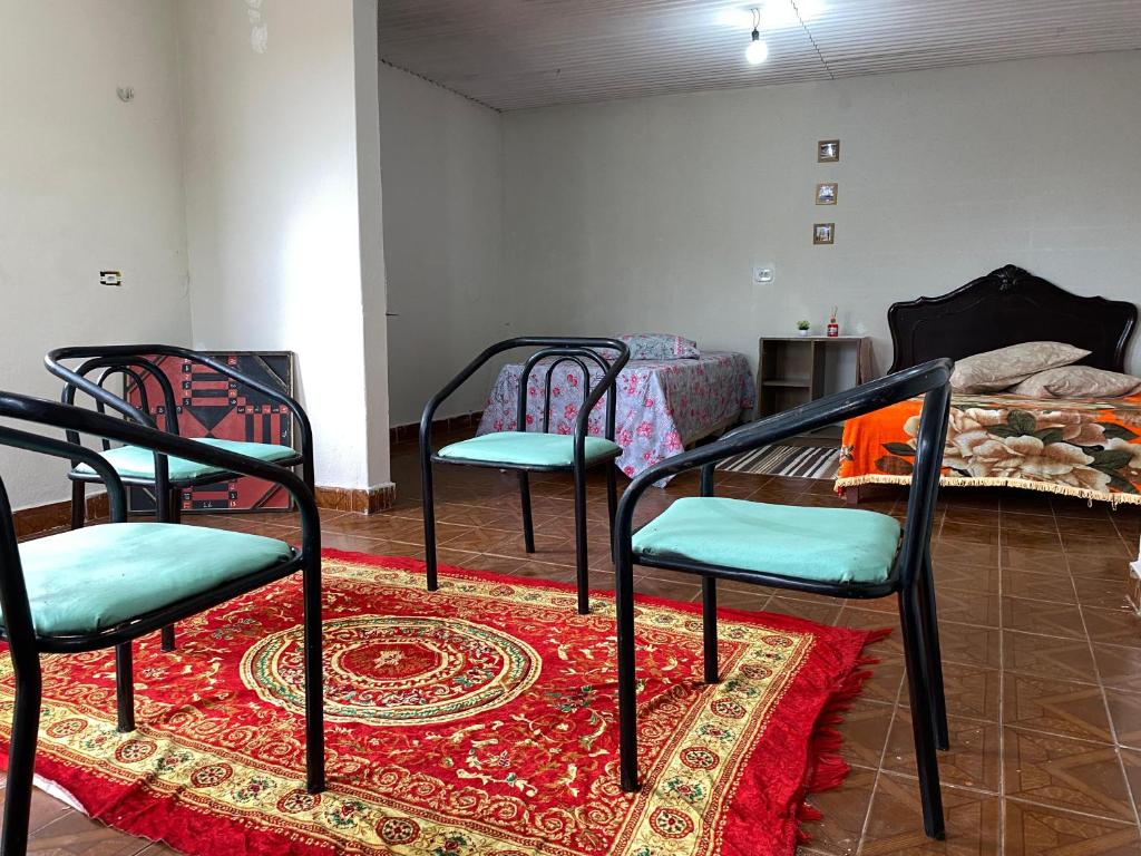 um quarto com três cadeiras e um tapete em Casa Gaita - Temporada em Triunfo