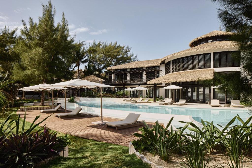 a resort with a swimming pool with chairs and umbrellas at Villa Abrazos in San Pedro