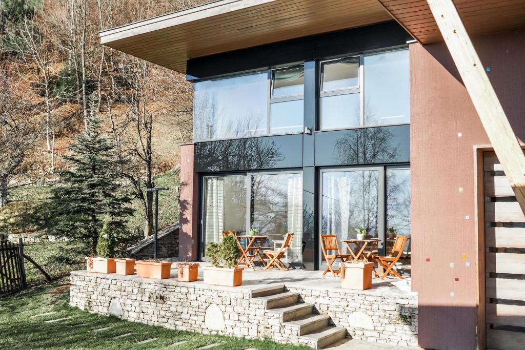 a house with glass walls and a patio at Hedona vineyard apartment in Sarajevo