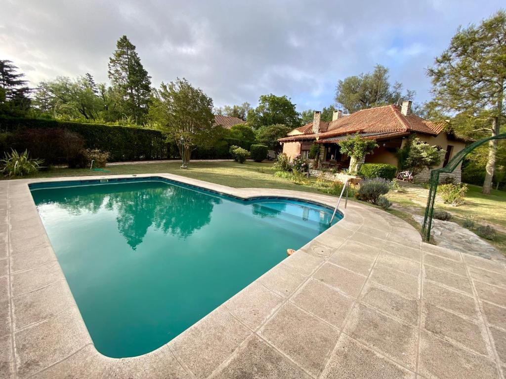 - une piscine dans une cour avec une maison dans l'établissement La Bedoya, à La Cumbre