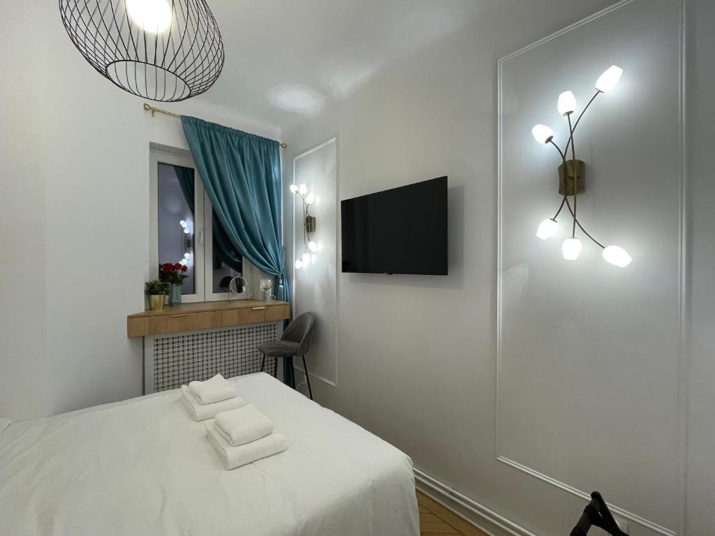 a bedroom with a bed and a tv on a wall at Studio Alice Romana Square in Bucharest