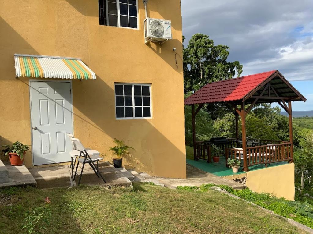 a house with a gazebo and a table at POINCIANA APARTMENT ONE 257 POINCIANA DRIVE GREEN WOOD MONTEGO BAY JAMAICA in Montego Bay