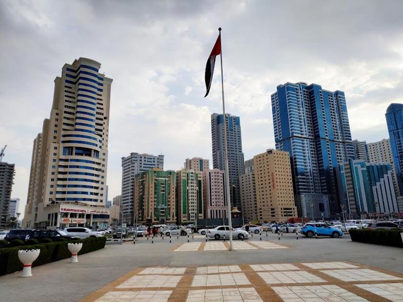 uma bandeira a hastear numa cidade com edifícios altos em El massa Quit apartment em Sharjah