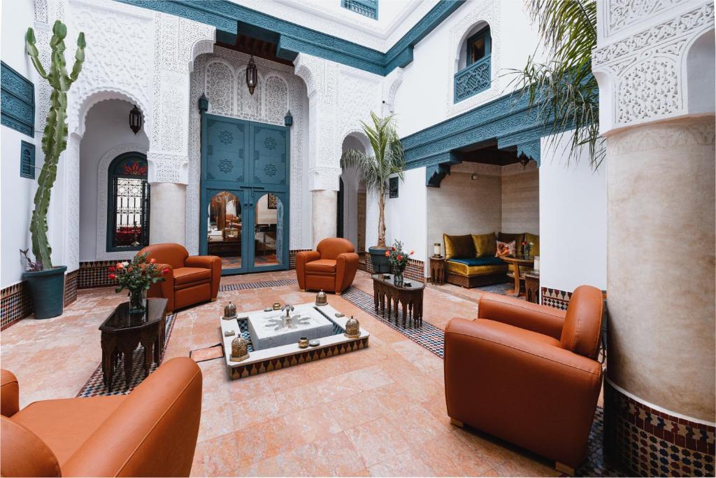 een lobby met banken en stoelen in een gebouw bij Riad Dar Alhambra in Marrakesh