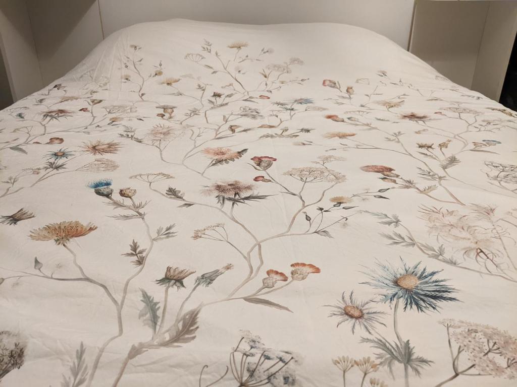 a bed with a floral print on a bedsheet at Paris Disney - Clim - Terrasse Sud dans nature in Sucy-en-Brie