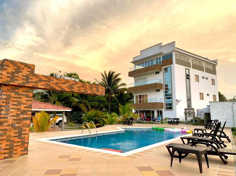 ośrodek z basenem i budynkiem w obiekcie Cabaña Coralina Casa Playa w mieście Juan de Acosta