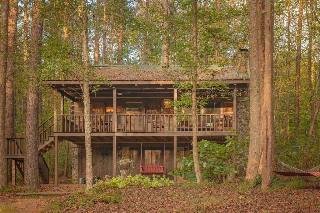 una casa en el árbol con terraza en el bosque en The Pines Riverside Log Cabin On The Ocoee, en Ocoee