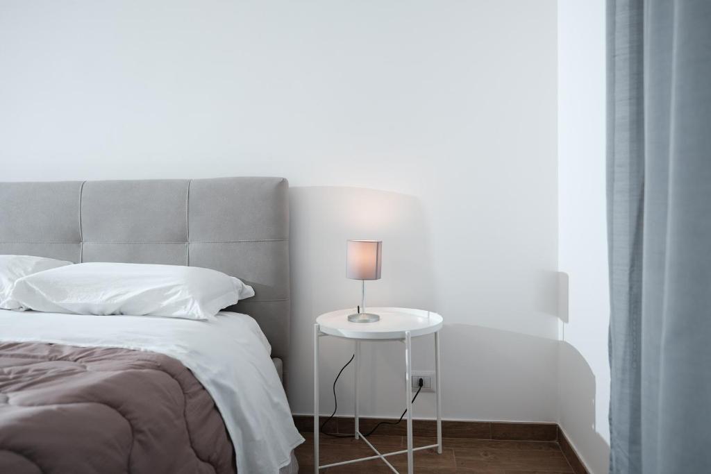 een slaapkamer met een bed en een tafel met een lamp bij CIVICO 15 APARTMENT in Mercato San Severino