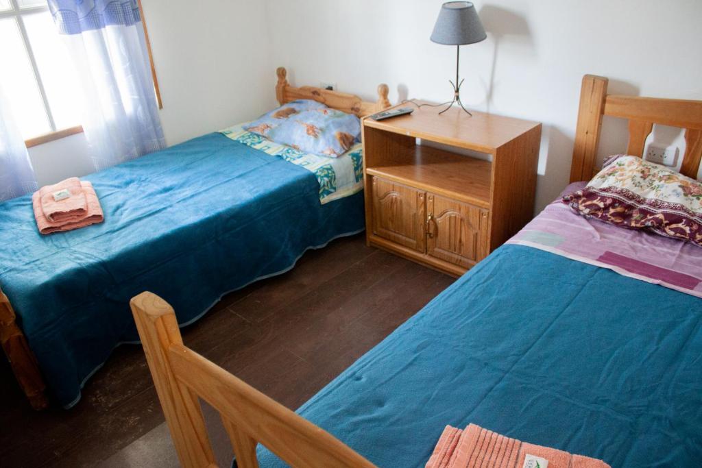a bedroom with two beds and a wooden dresser at Hope del Bosque in Ushuaia