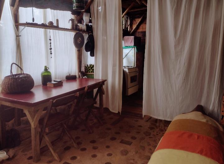a living room with a table and a tv in a room at Cabana Ecológica Trindade Paraty in Paraty