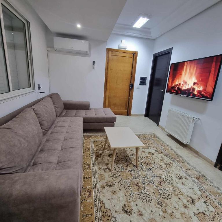 a living room with a couch and a coffee table at Spacious Apartment Ennasr 2 in Ariana
