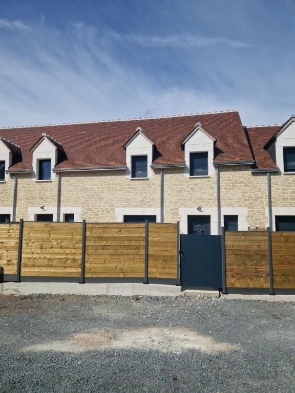 ein Holzzaun vor einem Haus in der Unterkunft Maison neuf pour 4 personnes 85m2 in Montlouis-sur-Loire