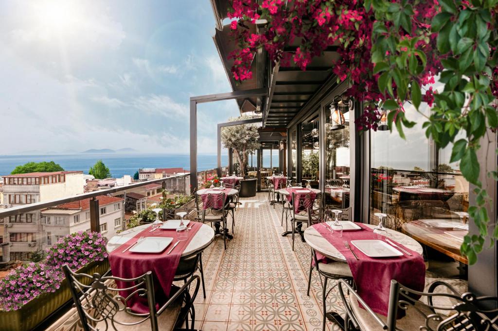 a restaurant with tables and chairs on a balcony at Skalion Hotel & SPA in Istanbul