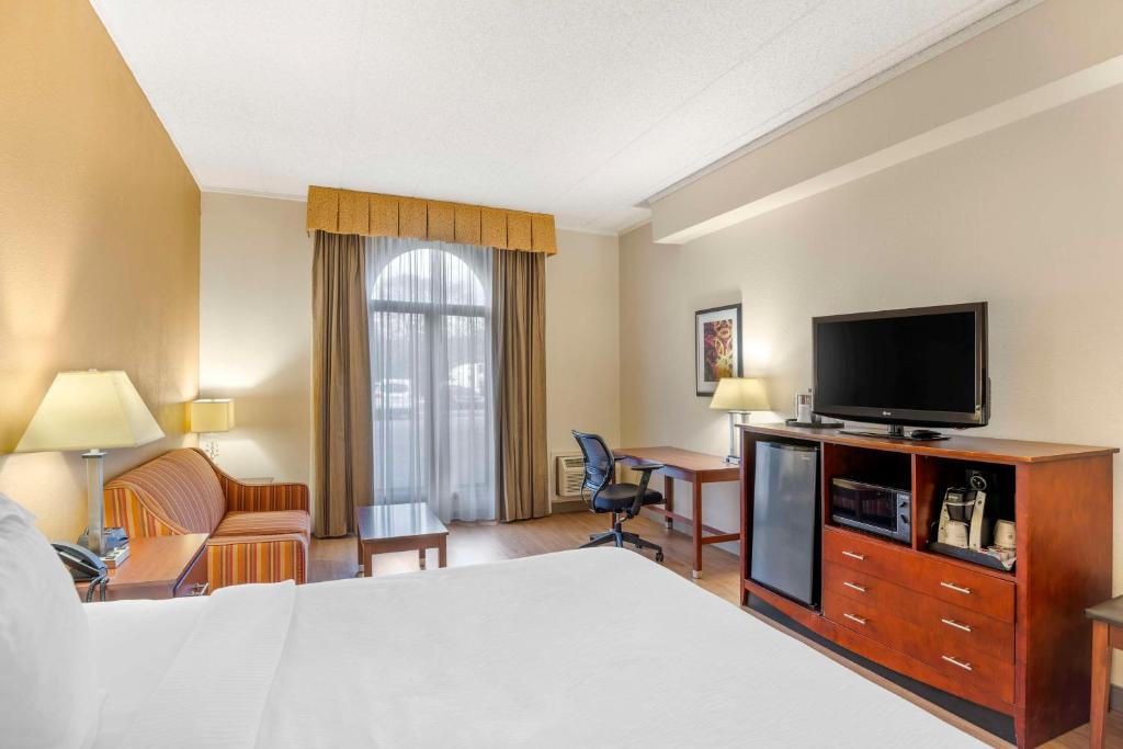 a hotel room with a bed and a flat screen tv at Best Western PLUS Governor's Inn Richmond in Midlothian