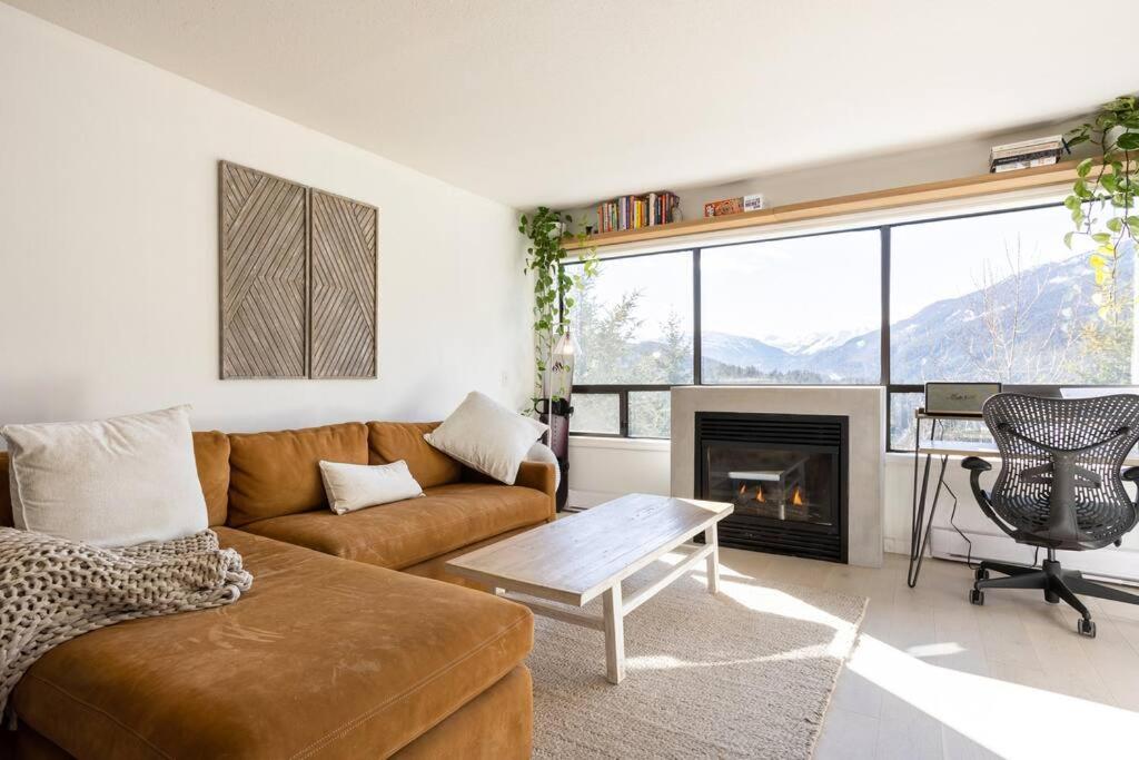 sala de estar con sofá y chimenea en Amazing Views 2 BR/2 BA Ski In Ski Out Condo en Whistler